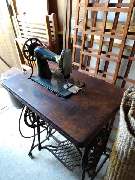 A vintage singer sewing machine is pictured sitting in our garage.